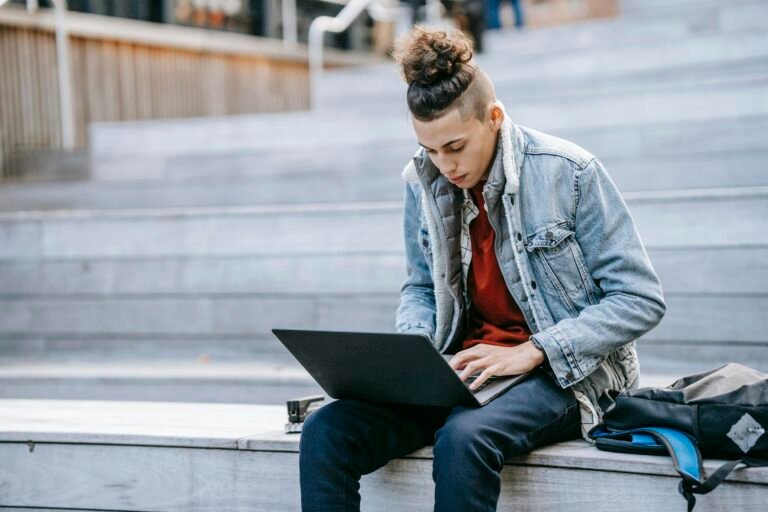 Focused man browsing laptop on wooden stairs